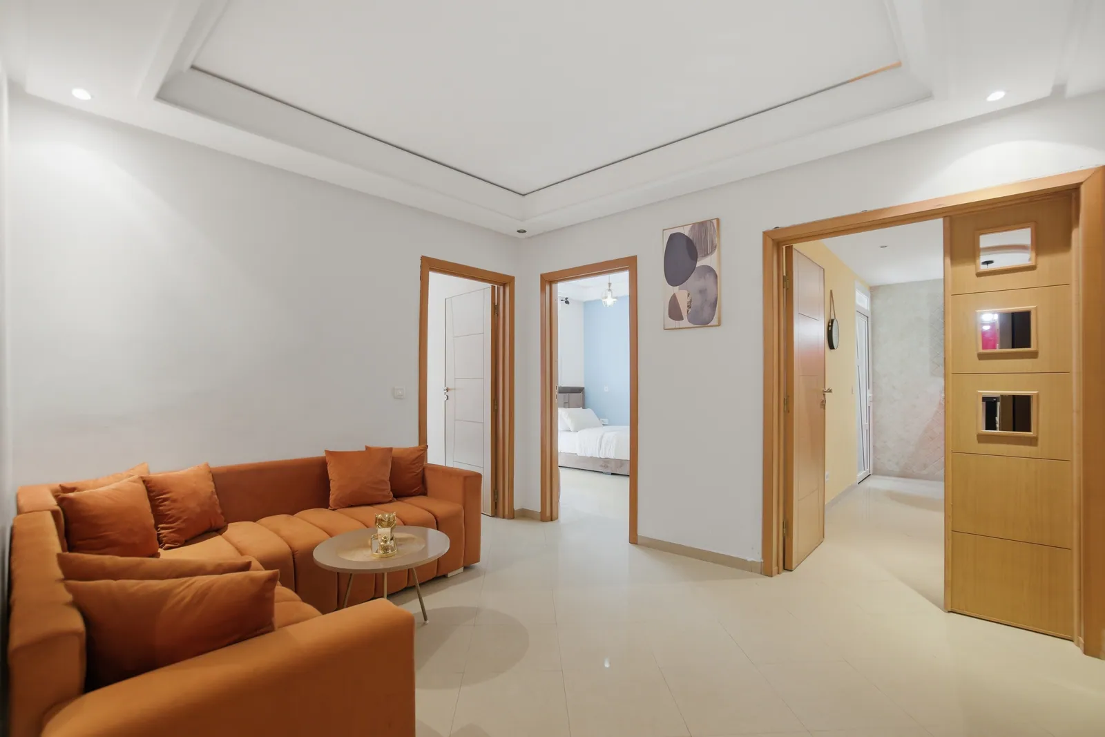 Second lounge area with orange velvet sofas and access to bedrooms