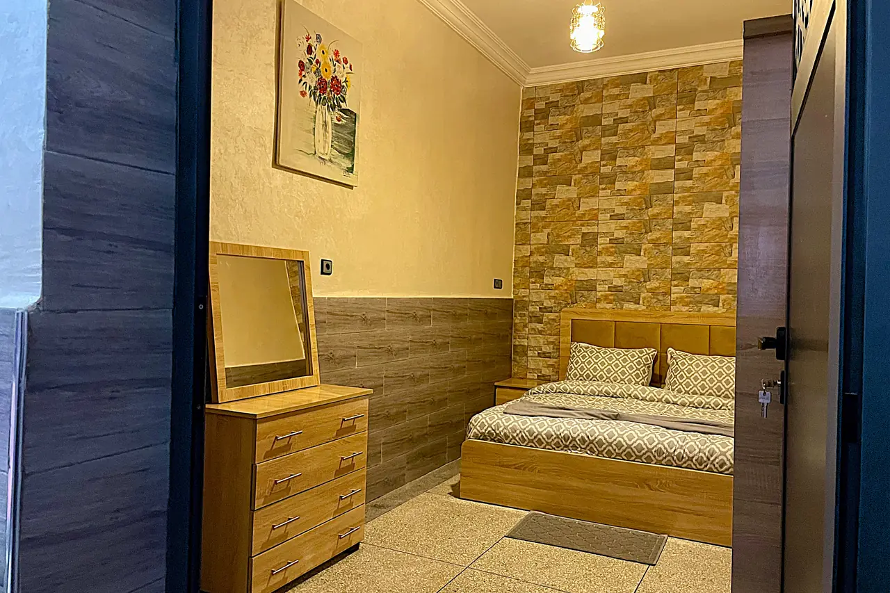 Chambre avec lanterne marocaine artisanale et commode en bois