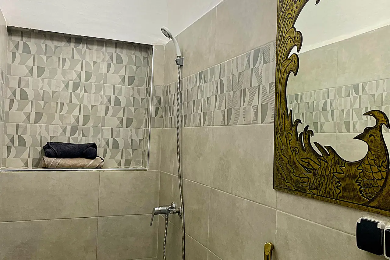 Salle de bain moderne avec douche à l'italienne et miroir doré orné de style marocain